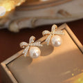 Elegantes Pendientes de Botón con Perla y Lazo de Mariposa en Strass