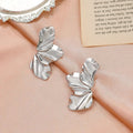 Aretes de botón media flor en plata