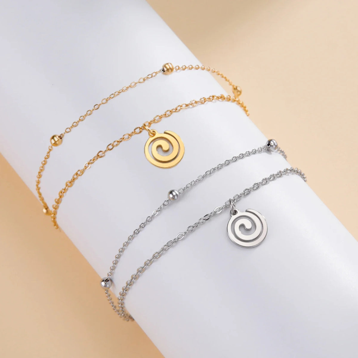 Pulsera dorada con pequeña dije espiral dorado