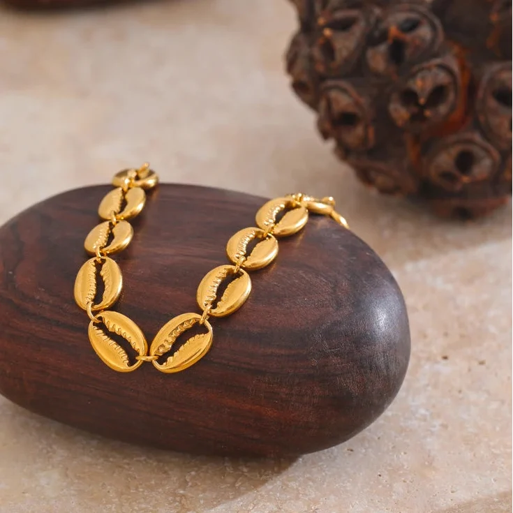 Pulsera dorada con concha cauri