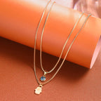 Collar doble con colgante Ojo Azul Turco y Mano de Fátima en oro
