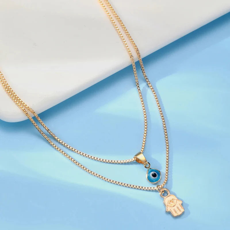 Collar doble con colgante Ojo Azul Turco y Mano de Fátima en oro
