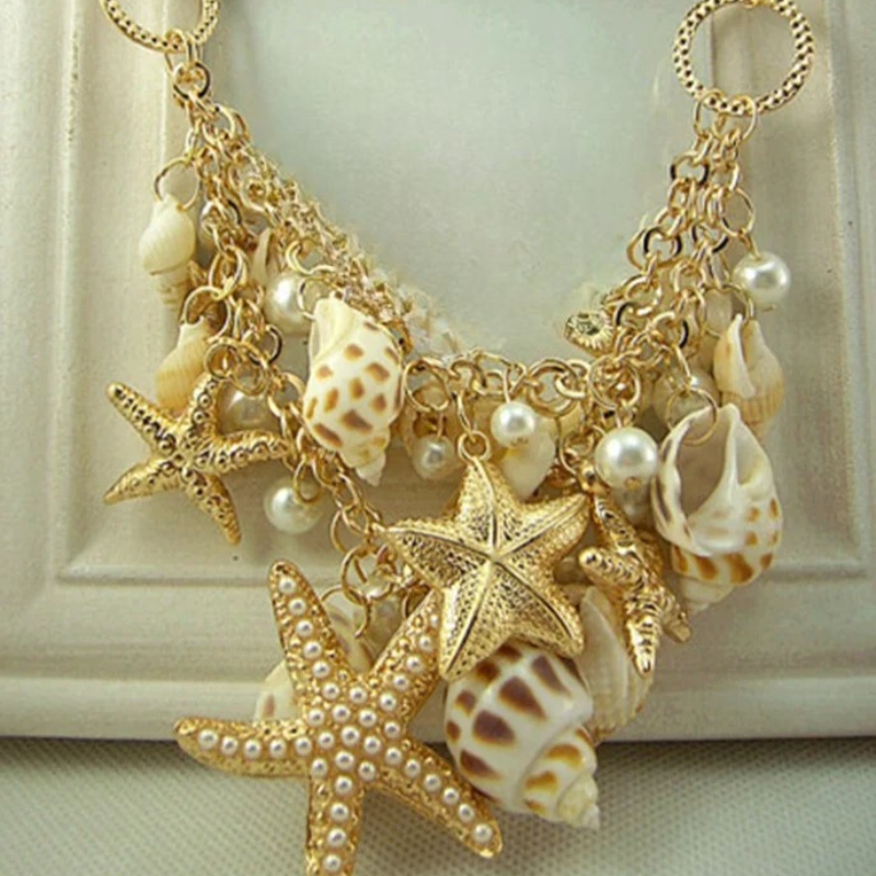 Collar con colgantes de conchas, estrellas de mar, caracoles y perlas