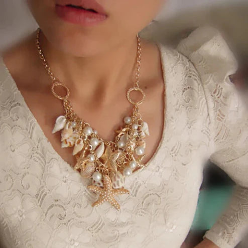 Collar con colgantes de conchas, estrellas de mar, caracoles y perlas