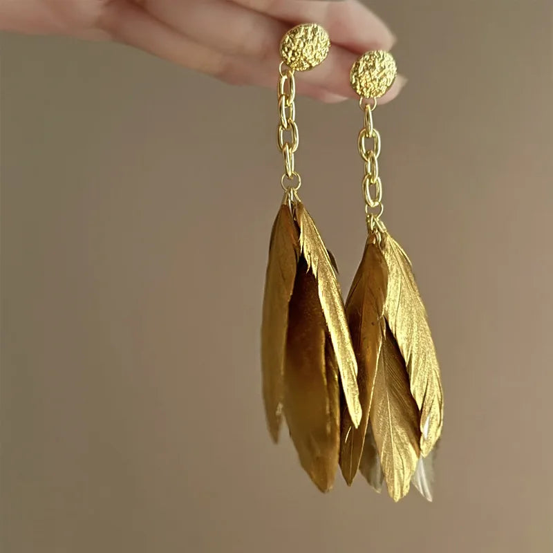 Aretes grandes con plumas doradas