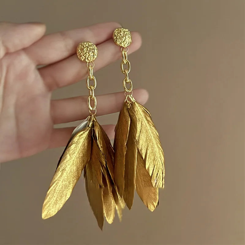 Aretes grandes con plumas doradas