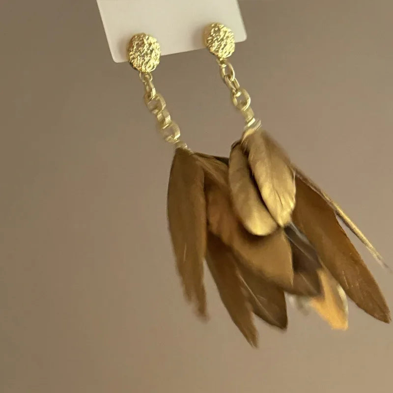 Aretes grandes con plumas doradas