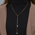 Collar largo con colgante y perlas doradas